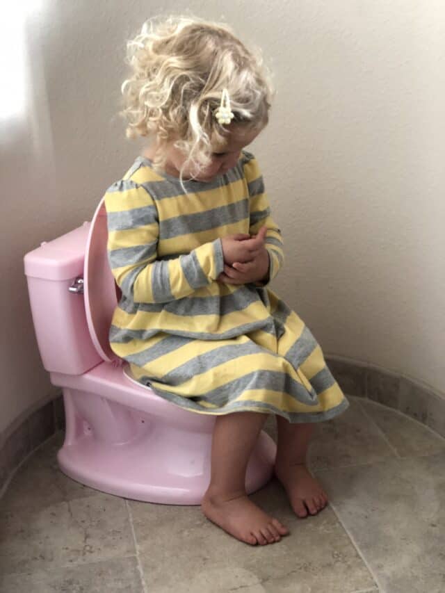 little girl sitting on a pretend potty