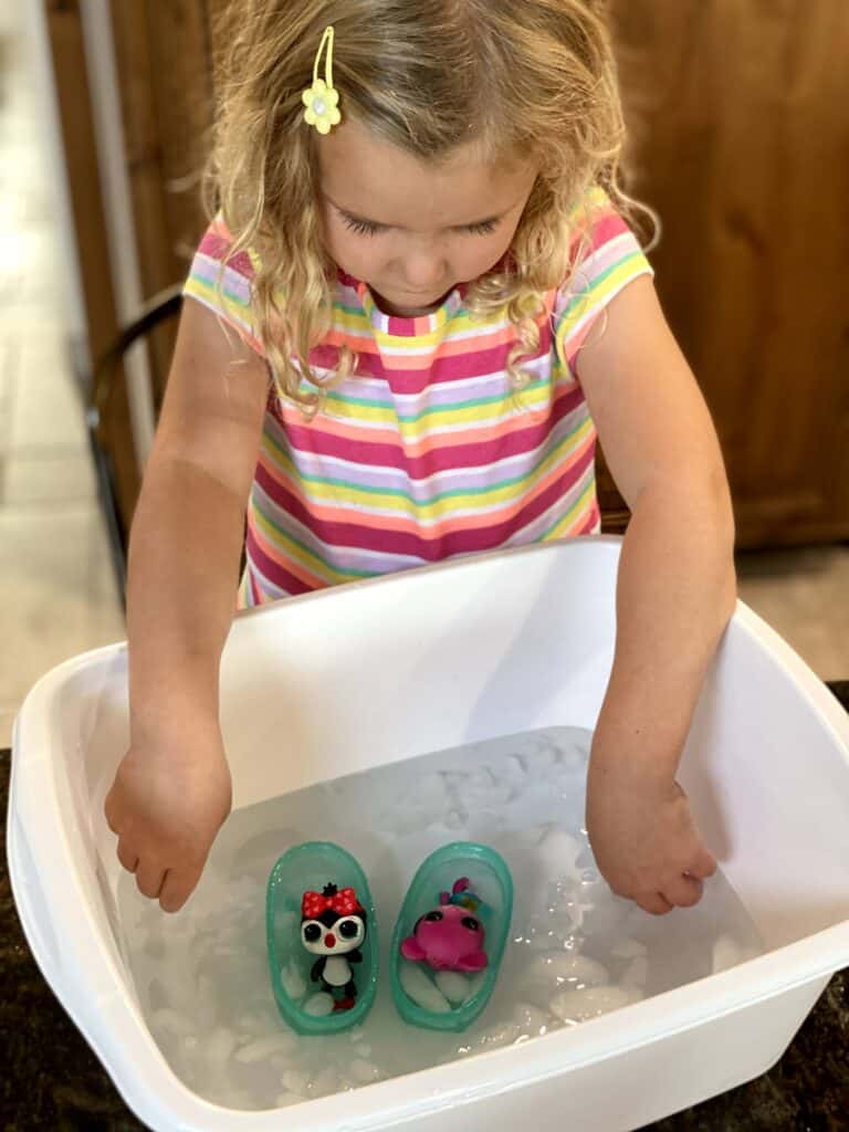Girl playing with two Baby born pet toys in an ice bath