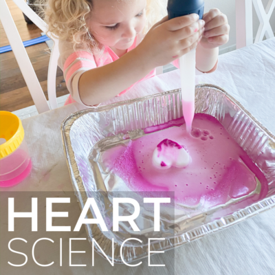 Girl squeezes vinegar onto a frozen baking soda heart