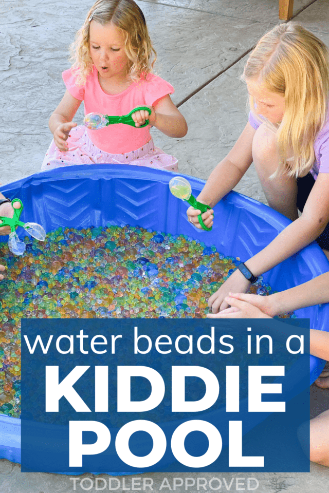 two kids playing with water beads in a kiddie pool